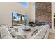 Open living room with tall ceilings, stone accent wall, grand piano, and an open patio view at 2436 Grassy Spring Pl, Las Vegas, NV 89135