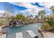 Beautiful pool with a rock waterfall feature and comfortable lounge chairs for relaxing in the sun at 2436 Grassy Spring Pl, Las Vegas, NV 89135