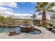 Gorgeous pool and spa combo with stone accents, overlooking lush landscaping and golf course views at 2436 Grassy Spring Pl, Las Vegas, NV 89135