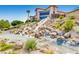 Stunning community waterfall feature cascading down rocks, surrounded by lush plants, enhancing the aesthetic appeal at 2784 Cherrydale Falls Dr, Henderson, NV 89052