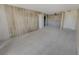 Living room featuring neutral carpet, wood wall accents, and multiple entryways at 2867 Geary Pl # 3008, Las Vegas, NV 89109