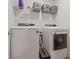 Laundry room with modern white washer and dryer and wire shelving at 2945 Torreon Ln, Las Vegas, NV 89121