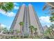Stunning high-rise exterior with palm trees, lush landscaping, and a grand entrance under a clear blue sky at 322 Karen Ave # 2003, Las Vegas, NV 89109