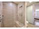 Elegant bathroom featuring a glass-enclosed shower with bench and neutral tile at 3722 Las Vegas Blvd # 1204, Las Vegas, NV 89158