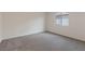 Cozy bedroom with soft carpet, white walls, and a view to the backyard at 4249 Gold Desert St, North Las Vegas, NV 89032