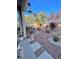 Well-maintained backyard with rock landscaping, a mature palm tree, and a covered patio area at 4534 Regalo Bello St, Las Vegas, NV 89135