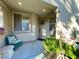 Inviting front porch with a cozy chair, side table and potted plants creating a welcoming entrance at 4534 Regalo Bello St, Las Vegas, NV 89135