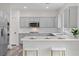 Modern kitchen features gray cabinetry, quartz countertops, stainless steel appliances, and breakfast bar at 4905 Madre Maria Ct, North Las Vegas, NV 89031