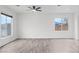 Bright living room featuring gray wood-look floors and a modern ceiling fan at 4905 Madre Maria Ct, North Las Vegas, NV 89031