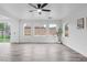 Bright living room with wood-look tile floors, ample natural light, and a modern ceiling fan at 4905 Madre Maria Ct, North Las Vegas, NV 89031