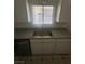 An updated kitchen featuring stainless steel sink and faucet, white cabinets, and tile flooring at 5129 Sugarfoot Ave, Las Vegas, NV 89107