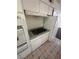 Gas cooktop in compact kitchen, white cabinets, neutral countertops, and light tile flooring at 5129 Sugarfoot Ave, Las Vegas, NV 89107