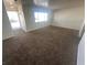 Neutral living room with carpet, large window, and glass paneled front door at 5129 Sugarfoot Ave, Las Vegas, NV 89107