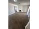 Spacious living room area featuring a brick fireplace, and neutral carpeting at 5129 Sugarfoot Ave, Las Vegas, NV 89107