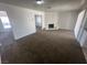 Spacious living room area featuring a brick fireplace, and neutral carpeting at 5129 Sugarfoot Ave, Las Vegas, NV 89107