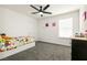 Bedroom with plush carpet, ceiling fan, and great natural light from a large window at 6130 Sinks Canyon Ave, Las Vegas, NV 89130