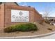 Rancho Crossing community sign made of red brick with green shrubbery and rock detail at 6130 Sinks Canyon Ave, Las Vegas, NV 89130