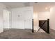 Hallway with carpet, white walls, dark railing, and a view of stairs leading downstairs at 6130 Sinks Canyon Ave, Las Vegas, NV 89130
