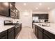 Modern kitchen features dark cabinetry, stainless steel appliances and ample countertop space at 6130 Sinks Canyon Ave, Las Vegas, NV 89130