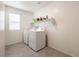 A functional laundry room features side-by-side washer and dryer and upper storage shelving at 6130 Sinks Canyon Ave, Las Vegas, NV 89130