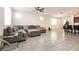 Open-concept living room with tile floors, a ceiling fan, and comfortable sectional sofa at 6130 Sinks Canyon Ave, Las Vegas, NV 89130