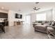 Spacious living room with tile flooring, ceiling fan, and a large sectional sofa at 6130 Sinks Canyon Ave, Las Vegas, NV 89130