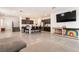 Open living space with tile flooring, a kitchen island with bar stools, and a large TV at 6130 Sinks Canyon Ave, Las Vegas, NV 89130