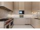 A chef's kitchen featuring stainless steel appliances, light wood cabinetry, and a geometric backsplash at 63 Midnight Sky Dr, Las Vegas, NV 89135