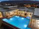A sparkling pool and hot tub are the focal point of the outdoor living space at twilight at 63 Midnight Sky Dr, Las Vegas, NV 89135