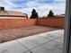 Enclosed backyard with a concrete patio and brick wall for privacy at 6608 Elk Creek Ln, Las Vegas, NV 89156