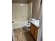 Cozy bathroom features a tub, toilet, vanity with a solid surface top, and wood look flooring at 6608 Elk Creek Ln, Las Vegas, NV 89156
