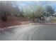 Street view of a quiet neighborhood with a well-maintained landscape and block wall in the background at 6615 Montezuma Castle Ln, North Las Vegas, NV 89084