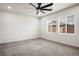 Spacious bedroom with neutral carpet, a ceiling fan, and ample natural light from large windows at 6630 Windy Palm St, North Las Vegas, NV 89086