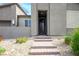 Inviting front entrance with stone steps and desert landscaping, leading to a secure front door at 6630 Windy Palm St, North Las Vegas, NV 89086