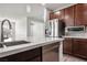 Modern kitchen featuring stainless steel appliances, a white quartz island and a view to the living room at 6630 Windy Palm St, North Las Vegas, NV 89086