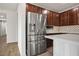 Modern kitchen with stainless steel refrigerator, beautiful backsplash, and dark wood cabinets at 6630 Windy Palm St, North Las Vegas, NV 89086
