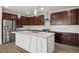 Modern kitchen with stainless steel appliances, dark wood cabinets, a white countertop island, and stylish backsplash at 6630 Windy Palm St, North Las Vegas, NV 89086