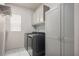 Laundry room featuring tile floors, modern washer/dryer and built-in storage at 6630 Windy Palm St, North Las Vegas, NV 89086