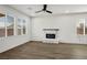 Open-concept living room featuring hardwood flooring, a ceiling fan, and a modern fireplace for a cozy ambiance at 6630 Windy Palm St, North Las Vegas, NV 89086