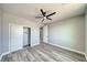 Cozy bedroom with wood-look floors, a ceiling fan, and closet space at 6631 S Parkwood Ct, Pahrump, NV 89061