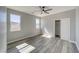 Bright bedroom featuring wood-look floors, two windows, and a closet at 6631 S Parkwood Ct, Pahrump, NV 89061