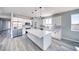 Modern kitchen with white cabinets, a large island with marble countertop and stainless appliances at 6631 S Parkwood Ct, Pahrump, NV 89061