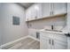Compact laundry room features white cabinets and a utility sink at 6631 S Parkwood Ct, Pahrump, NV 89061