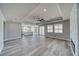 Open-concept living room with wood-look floors, tray ceiling, and lots of natural light at 6631 S Parkwood Ct, Pahrump, NV 89061