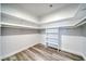 Walk-in closet featuring laminate wood flooring, shelving and hanging rods, and white trim at 6650 Raintree Ct, Pahrump, NV 89061