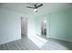 Light-filled bedroom showcasing a ceiling fan, neutral walls, and attached bathroom at 6925 Cuddy Falls Pl, North Las Vegas, NV 89084