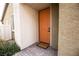 Exterior view of an orange front door framed by textured walls and a welcome mat at 6925 Cuddy Falls Pl, North Las Vegas, NV 89084