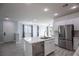 A bright kitchen featuring white cabinets, a stainless steel refrigerator, and an island at 6925 Cuddy Falls Pl, North Las Vegas, NV 89084