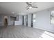 Spacious living room featuring modern gray flooring, a ceiling fan, and natural light at 6925 Cuddy Falls Pl, North Las Vegas, NV 89084