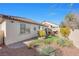 Landscaped backyard with pavers, patio, fire pit, built-in garden, and desert plants at 7148 Stanley Frederick St, Las Vegas, NV 89166